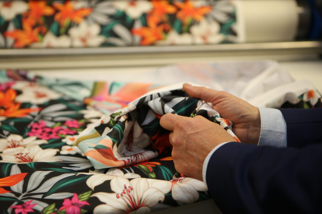 De inkt zit niet, zoals bij traditionele sublimatie, in het textiel, maar ligt erop.