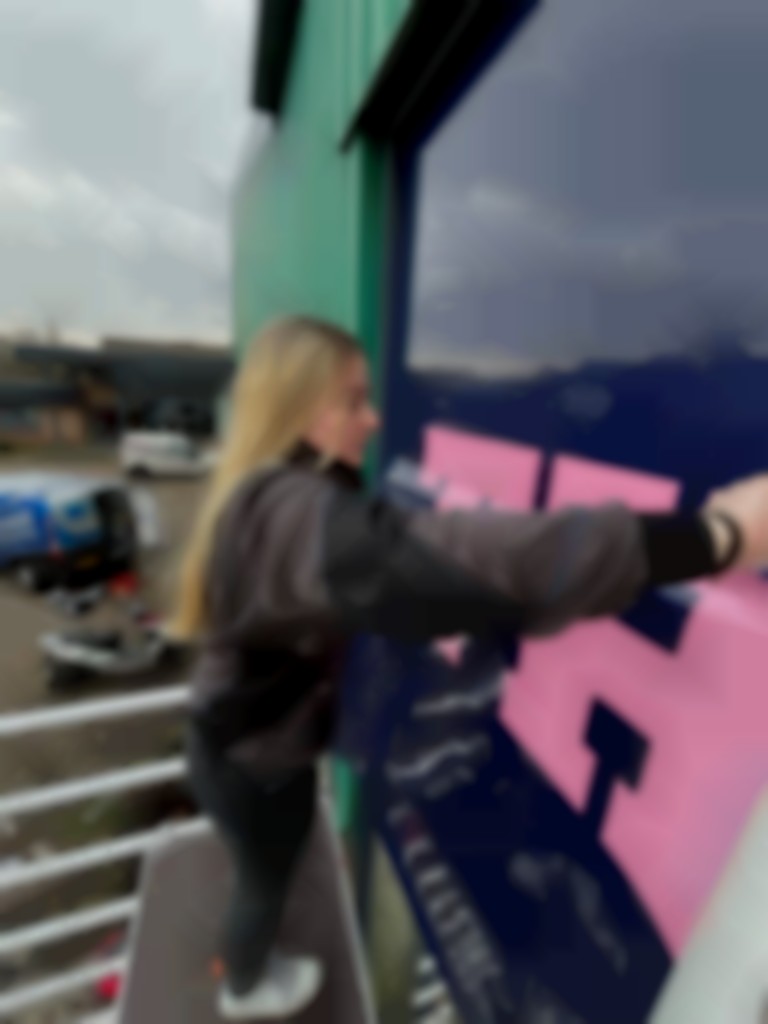 Kristien Stalman in actie aan een gevel.